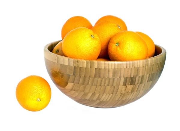Viele reife Orangen in großer Holzschale isoliert auf weiß — Stockfoto