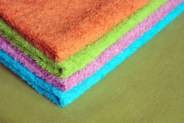 Four bath towels of different colors stacked closeup — Stock Photo, Image