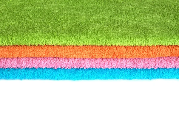 Vier badhanddoeken van verschillende kleuren gestapeld geïsoleerd — Stockfoto