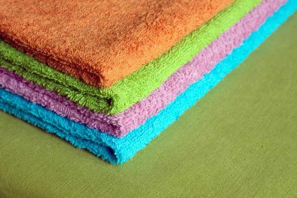 Four bath towels of different colors stacked closeup — Stock Photo, Image