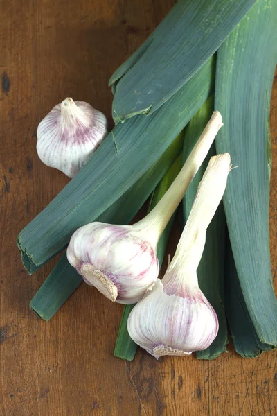 Prei en knoflook op houten achtergrond close-up — Stockfoto