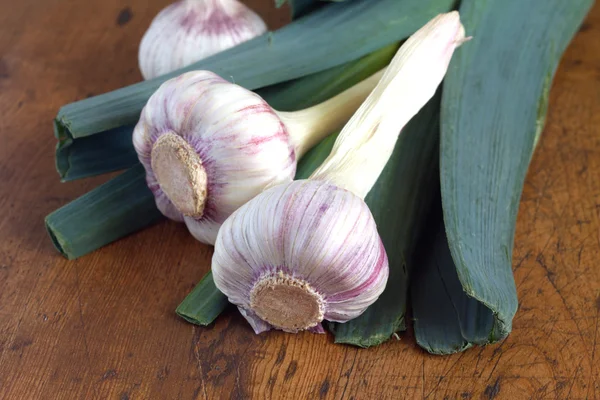 Prei en knoflook op houten achtergrond close-up — Stockfoto