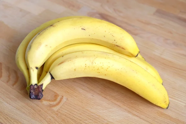 Plátanos aislados sobre fondo de madera — Foto de Stock