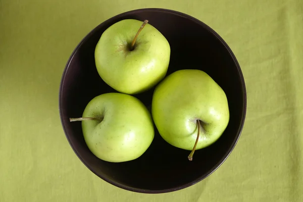 Three green apples inside purple bowl closeup — Stock Photo, Image