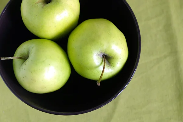 Drei grüne Äpfel in lila Schale Nahaufnahme — Stockfoto