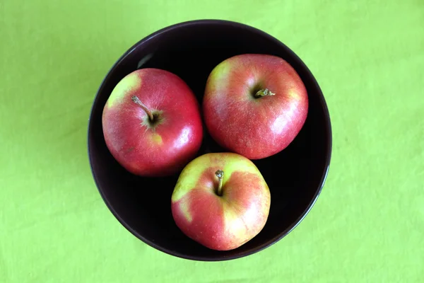 Three red apples inside purple bowl clos-up — Stock Photo, Image