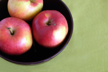 Mor kase yakın çekim içinde üç kırmızı elma