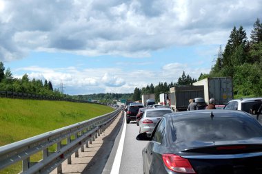 Moskova banliyösü, Rusya - 6 Haziran 2016: Kırsal otoyolda trafik sıkışıklığı. Güneşli yaz gününde yolda hareketsiz duran bir sürü araba var.
