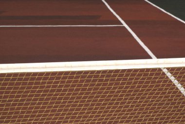 Kahverengi yüzey manzaralı boş kortta tenis ağı