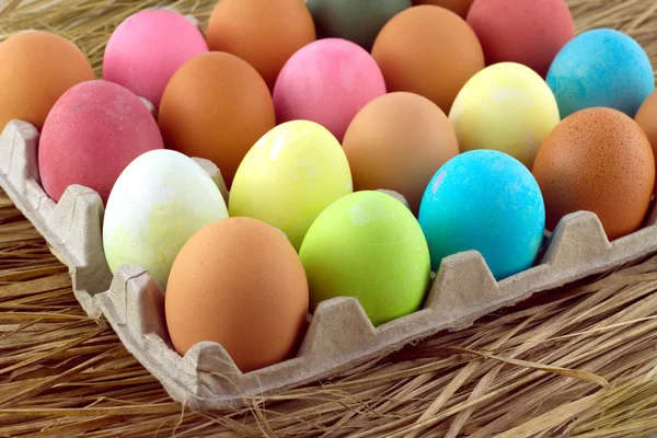 Painted Easter eggs lie in rows inside cells on a straw — Stock Photo, Image