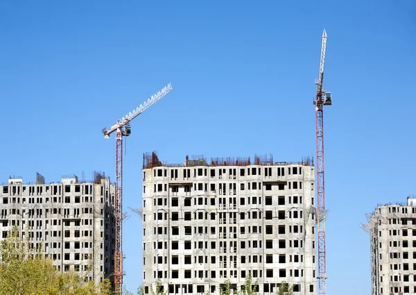 Hoisting tower cranes and top of construction buildings — Stock Photo, Image