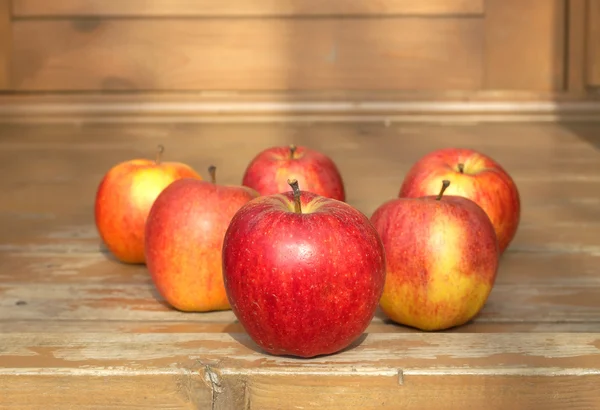 Ripe red and yellow apples on wooden floor closeup — Stock Photo, Image