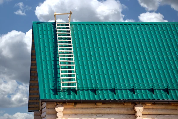 Part of new country house from logs and green metal tile roof — Stock Photo, Image