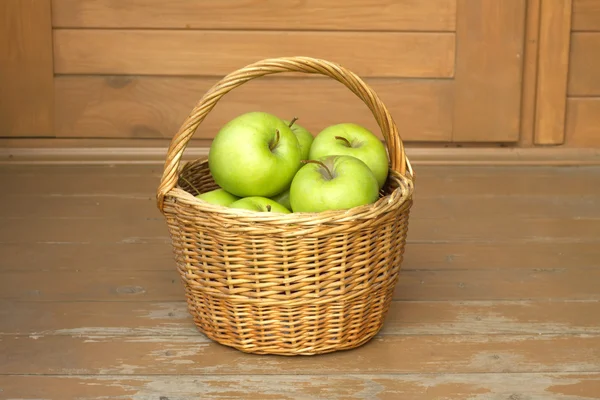 Dojrzałe jabłka zielone w Wiklinowy kosz zbliżenie — Zdjęcie stockowe