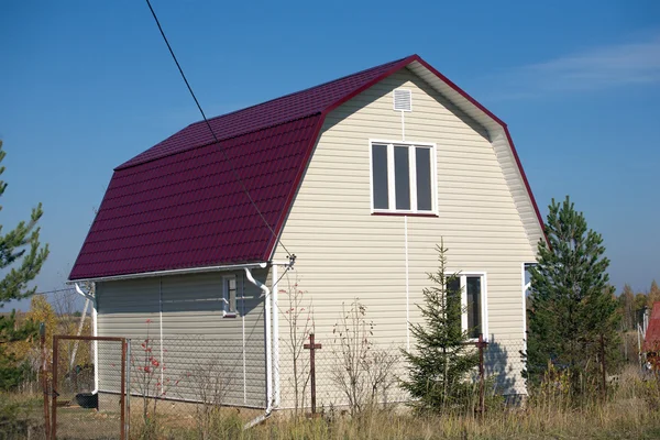 New built country house with red roof and covered with beige siding — Stock Photo, Image