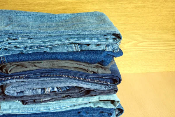 Gekleurde jeans op kast plank, vooraanzicht close-up — Stockfoto