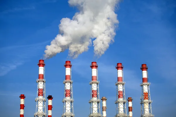 Industrial pipes with white smoke over blue sky. Horizontal photo — Stock Photo, Image