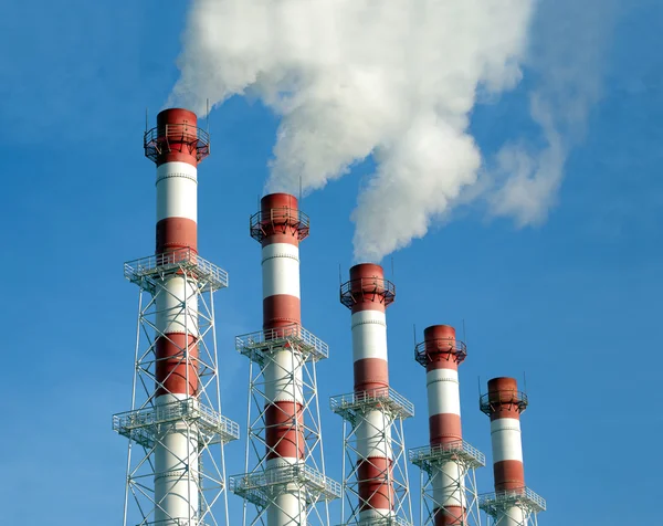 Industrial pipes with white smoke over blue sky, side view — Stock Photo, Image