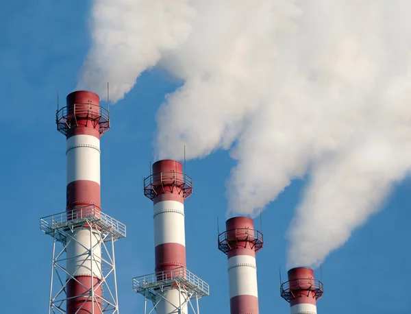 Industrirör med vit rök över blå himmel, sidovy — Stockfoto