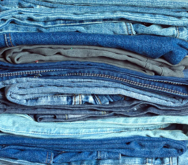 Pilha de muitos coloridos jeans dobrados close-up — Fotografia de Stock