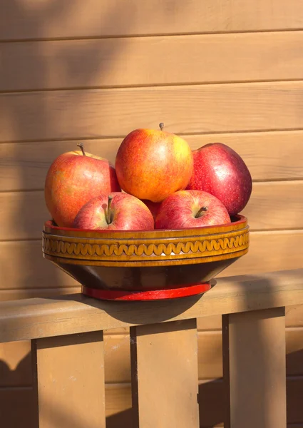 Ripe red and yellow apples in wooden bowl closeup — Stock Photo, Image
