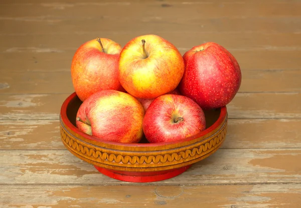 Ripe red and yellow apples in wooden bowl closeup — Stock Photo, Image