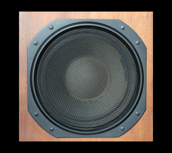 Subwoofer Loud speaker system with round black grill and wooden finish isolated on black closeup