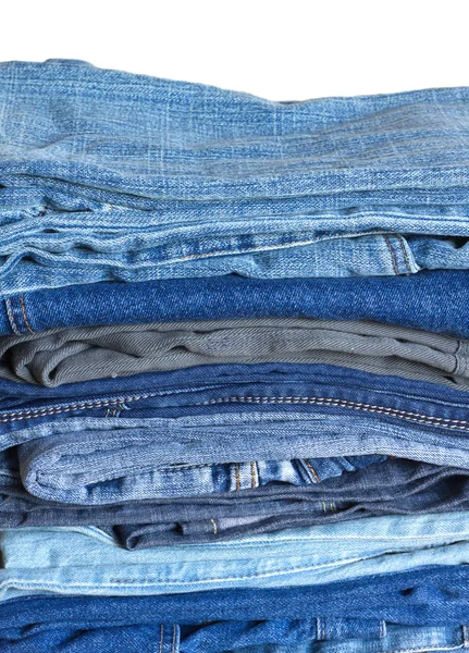 Empilhar em muitos jeans isolados em close-up branco — Fotografia de Stock