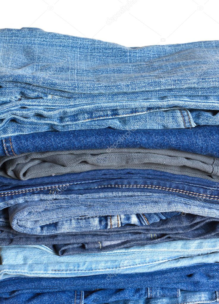 Stack on many jeans isolated on white close-up