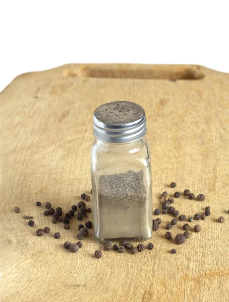 Pepper and spice jars on a board — Stock Photo, Image