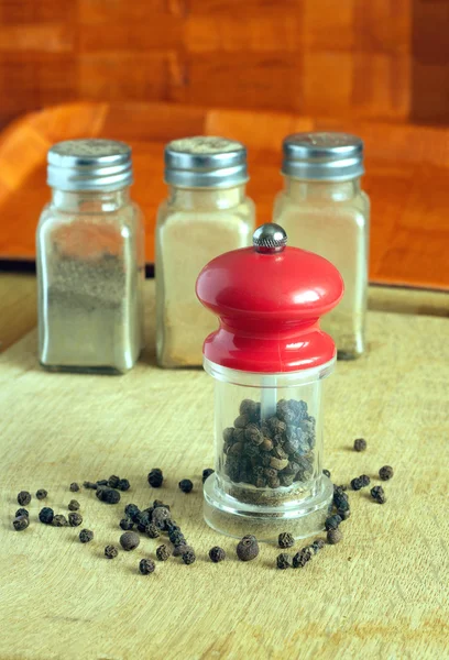 辣椒、 胡椒磨、 香料罐在厨房桌子上特写 — 图库照片