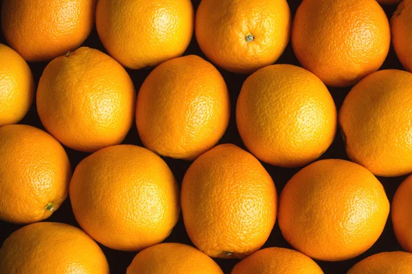 Sok érett narancs, mint háttér felett fekete coseup — Stock Fotó