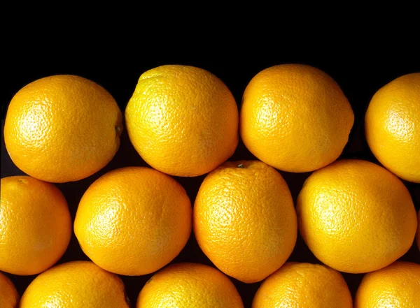 Many ripe oranges isolated on black — Stock Photo, Image