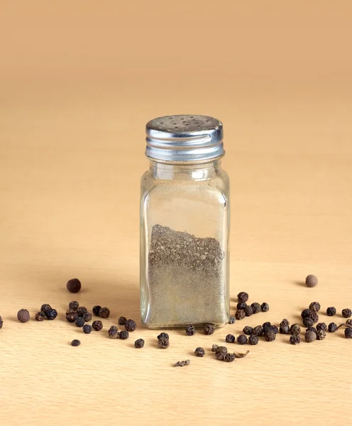 Pepper and spice jar on wooden surface closeup — Stock Photo, Image