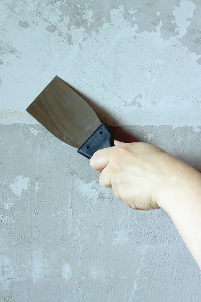 Kvinnlig hand med en spatel plåster betongvägg — Stockfoto