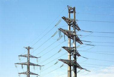 Yüksek voltajlı güç hattı metal sahne üzerinde net Bulutsuz mavi gökyüzü