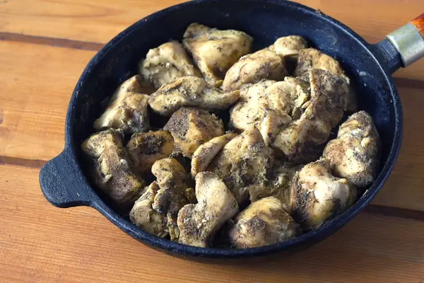 Poulet frit aux épices aromatiques sur une poêle noire — Photo