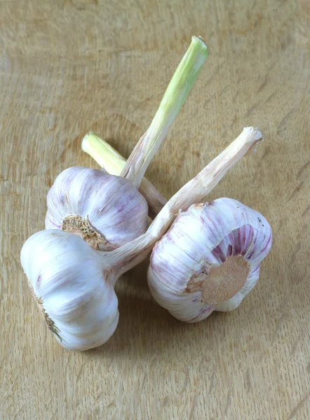 Heads of ripe garlic lie on wooden table — Stock Photo, Image