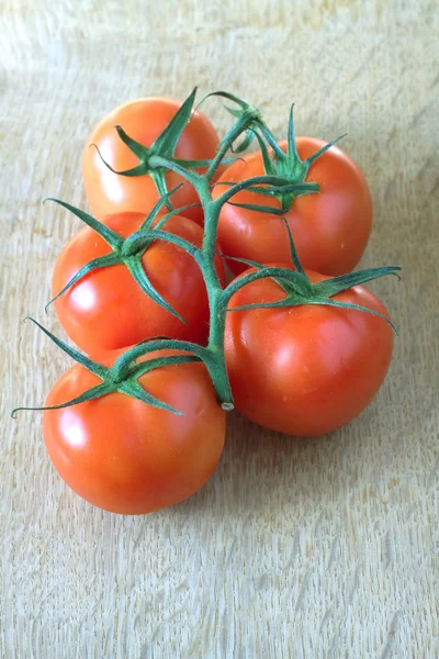 Red ripe tomatoes on green branch on a table — Stock Photo, Image