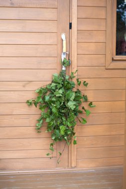 Huş sauna çırpma teli Kapıda asılı ele kahverengi ahşap kırsal banyoları