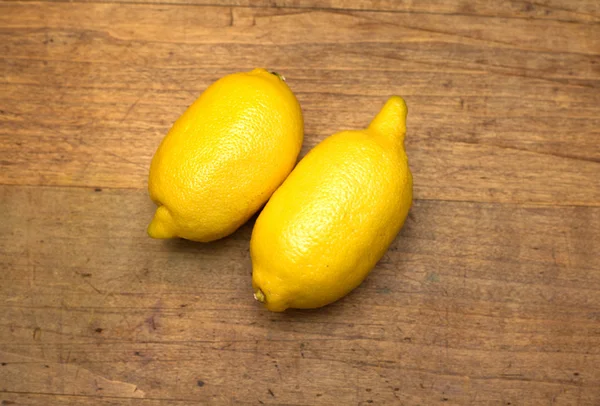 İki olgun sarı limon ahşap yüzeyde yatıyor — Stok fotoğraf