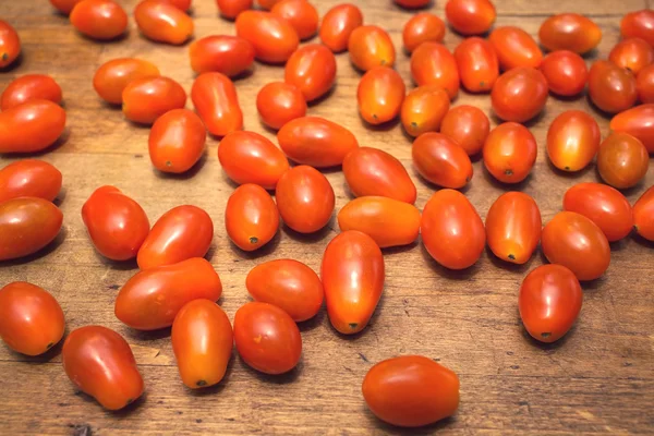 Wiele czerwony dojrzałe pomidory leży na powierzchni drewnianych — Zdjęcie stockowe