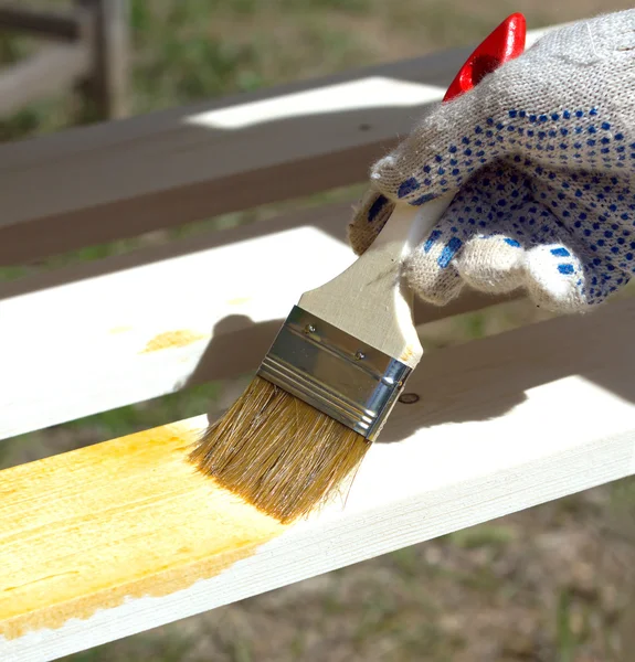 Hand verven bruin een houten meubilair buitenshuis close-up — Stockfoto