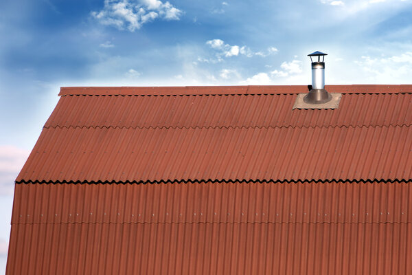 Gable roof of a house covered with metal tile with chimney