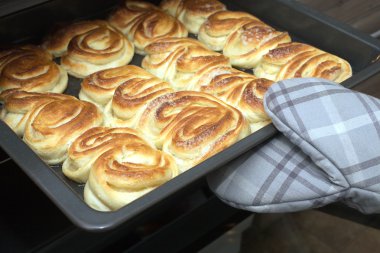 Hostes bitmiş gevrek kek mutfak fırından alır.