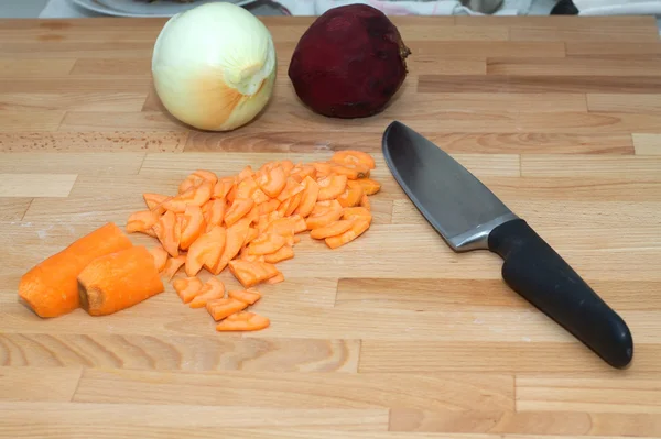 Gesneden wortelen en een grote stalen keuken mes close-up — Stockfoto