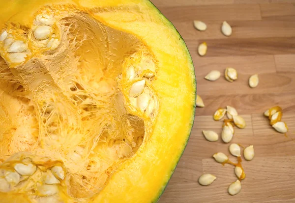 Still-life with half of large ripe pumpkin and seeds close-up — Stock Photo, Image