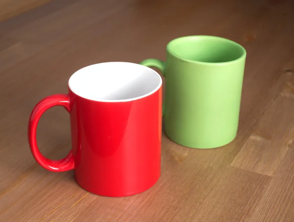 Czerwony i zielony puste filiżanki herbaty lub kawy na tle drewniane closup — Zdjęcie stockowe