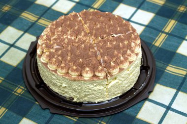 Masada yeşil kareli masa örtüsü üzerinde yuvarlak sünger kek