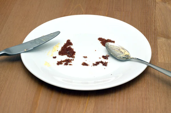 Placa branca redonda vazia com traços de close-up de bolo comido — Fotografia de Stock